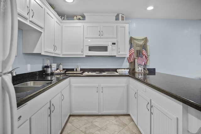 979 Sea Spray Dr, Crystal Beach, TX 77650 - kitchen with white appliances, white cabinets, light tile patterned floors, and recessed lighting