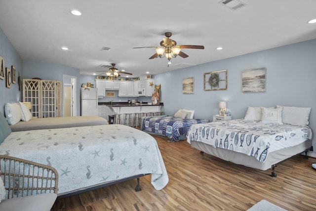 979 Sea Spray Dr, Crystal Beach, TX 77650 - bedroom with visible vents, recessed lighting, freestanding refrigerator, and wood finished floors