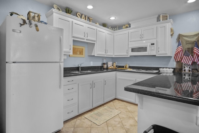 979 Sea Spray Dr, Crystal Beach, TX 77650 - kitchen with light tile patterned floors, white appliances, white cabinetry, and a sink
