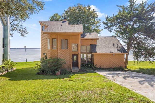 182 Cedar Hill Dr, Livingston, TX 77351 - view of front facade featuring a chimney, a water view, a front yard, and roof with shingles
