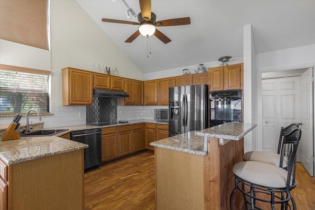 182 Cedar Hill Dr, Livingston, TX 77351 - kitchen featuring under cabinet range hood, black appliances, light stone counters, and a sink