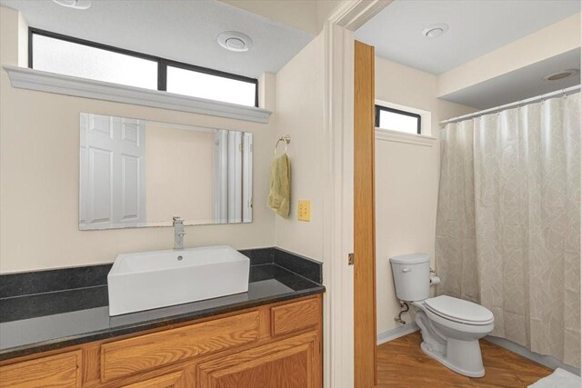 182 Cedar Hill Dr, Livingston, TX 77351 - full bathroom featuring vanity, a shower with shower curtain, toilet, and wood finished floors