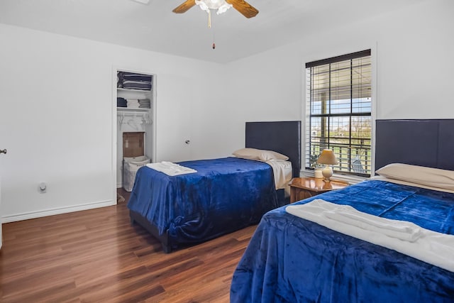 bedroom with ceiling fan, baseboards, and wood finished floors