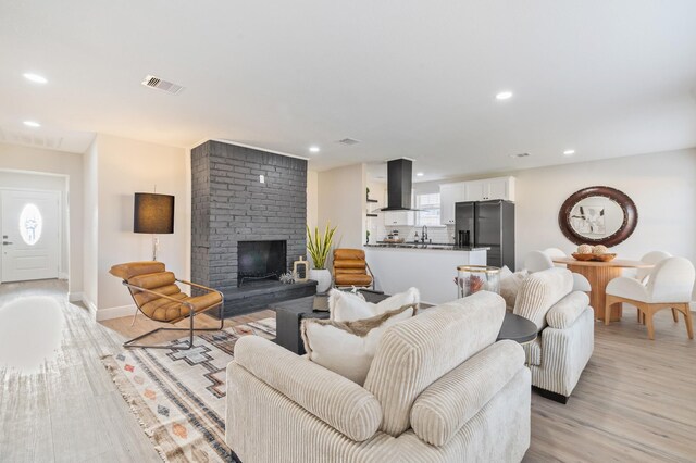 living room with visible vents, recessed lighting, light wood-style floors, a fireplace, and baseboards