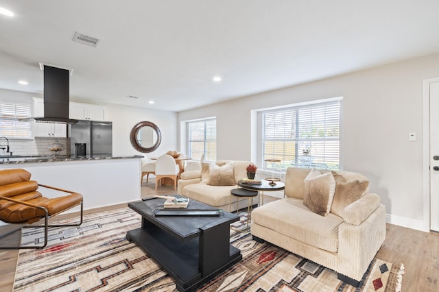 living room featuring recessed lighting, visible vents, light wood-style flooring, and baseboards