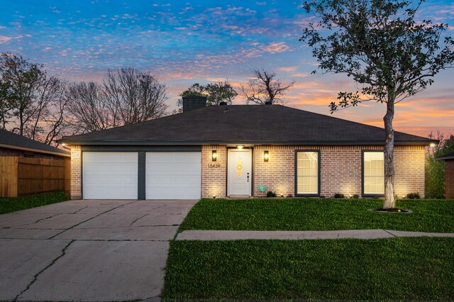 ranch-style home with a lawn, driveway, a garage, brick siding, and a chimney