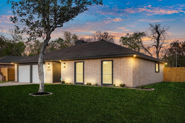 single story home with a front lawn, fence, concrete driveway, an attached garage, and brick siding