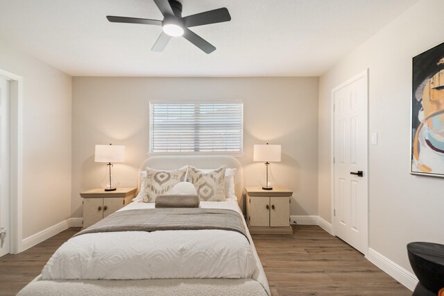 bedroom with a ceiling fan, baseboards, and wood finished floors