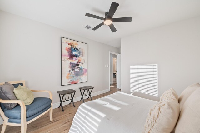 bedroom with visible vents, ceiling fan, baseboards, and wood finished floors