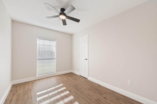 unfurnished room with a ceiling fan, wood finished floors, and baseboards