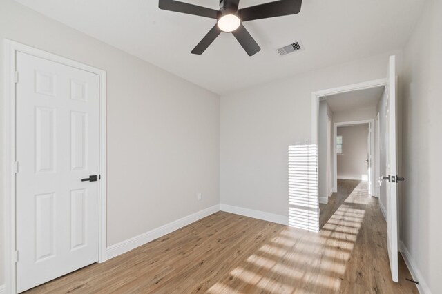 interior space featuring visible vents, baseboards, light wood-type flooring, and ceiling fan