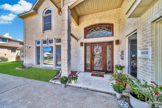 view of exterior entry featuring brick siding