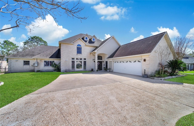 view of front facade with a shingled roof, an attached garage, a front lawn, brick siding, and driveway