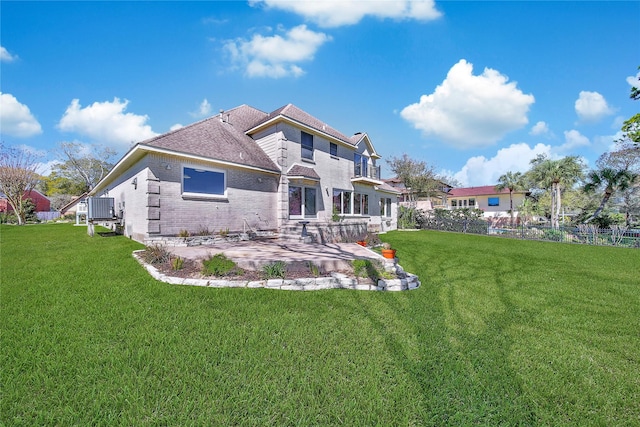 back of house featuring fence, a patio, a yard, and brick siding