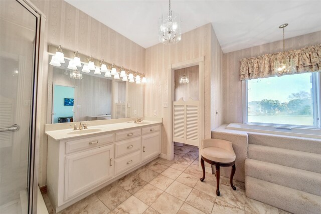 bathroom with double vanity, wallpapered walls, an inviting chandelier, and a sink
