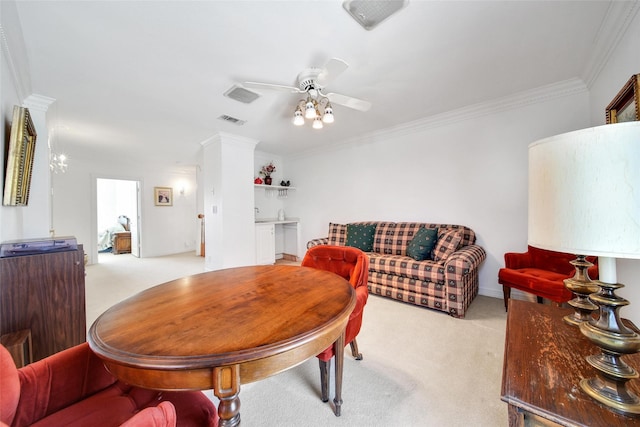 carpeted dining space featuring visible vents, decorative columns, crown molding, and ceiling fan