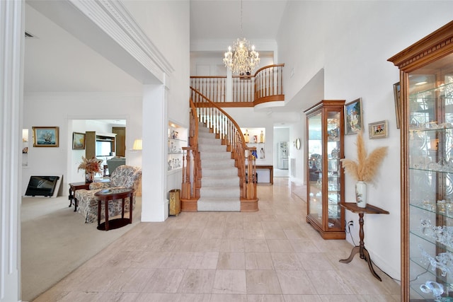 foyer with ornamental molding, stairs, a towering ceiling, baseboards, and a chandelier