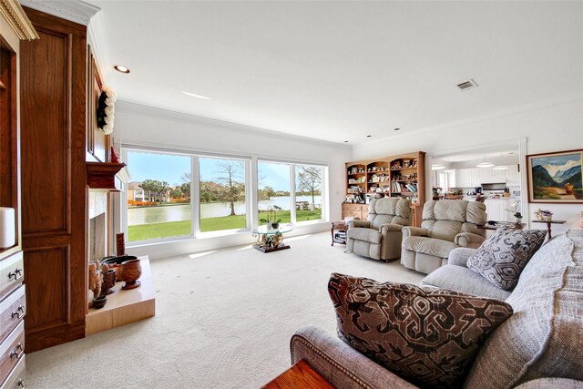 living area with a water view, visible vents, ornamental molding, and carpet