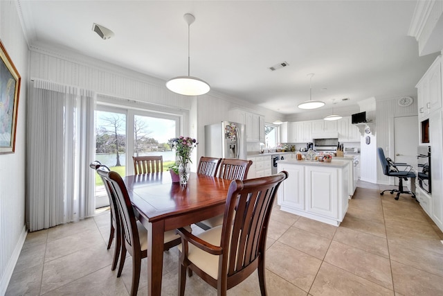 dining room with light tile patterned flooring, baseboards, visible vents, and ornamental molding