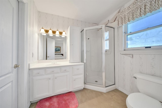 ensuite bathroom with toilet, wallpapered walls, a shower stall, and vanity