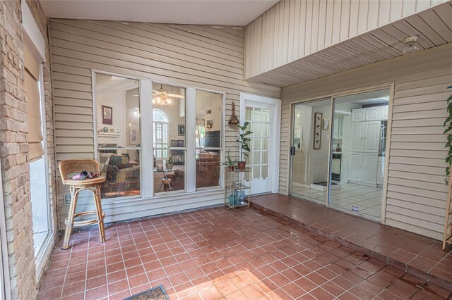 unfurnished sunroom with lofted ceiling and ceiling fan