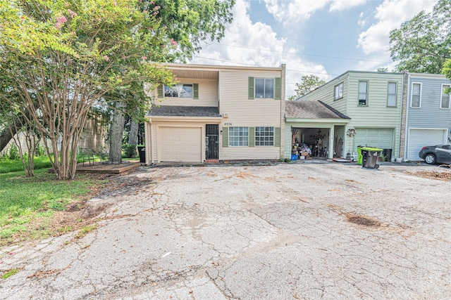 view of front facade with aphalt driveway, a shingled roof, and a garage