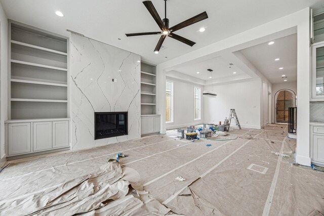 2244 N Blvd, Houston, TX 77098 - unfurnished living room featuring built in shelves, a high end fireplace, recessed lighting, baseboards, and arched walkways