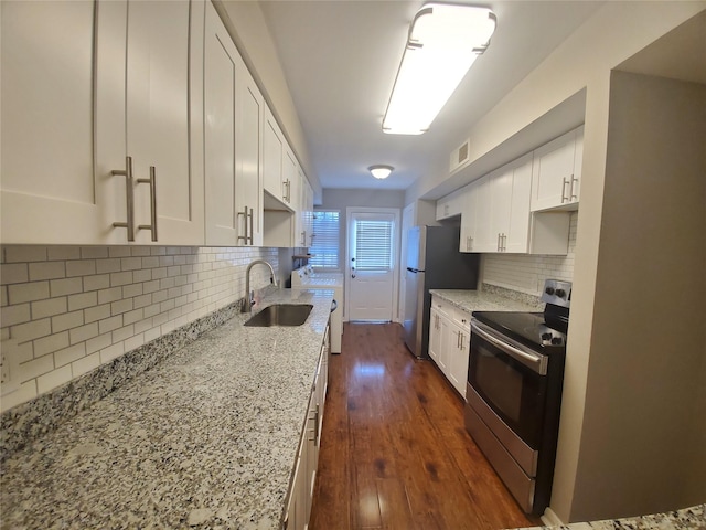kitchen with light stone counters, dark wood-style floors, white cabinets, stainless steel appliances, and a sink