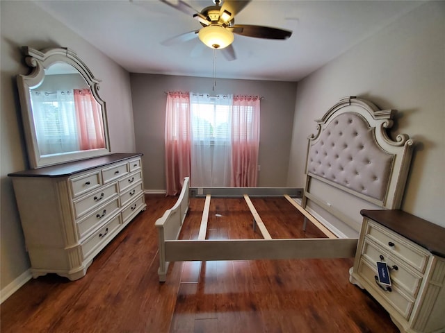 bedroom with a ceiling fan, dark wood-style floors, and baseboards