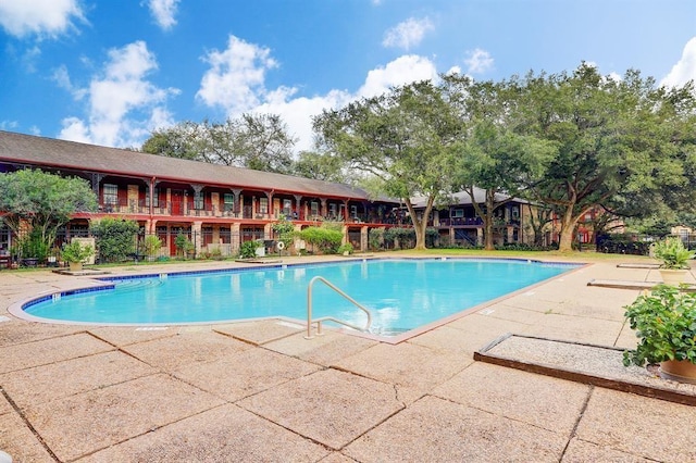 pool with a patio and fence
