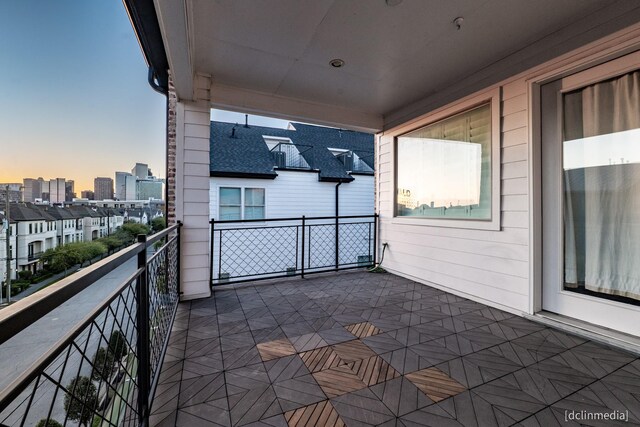 balcony at dusk featuring a city view
