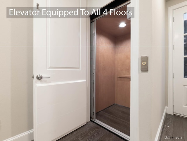 bathroom with elevator, wood finished floors, and baseboards