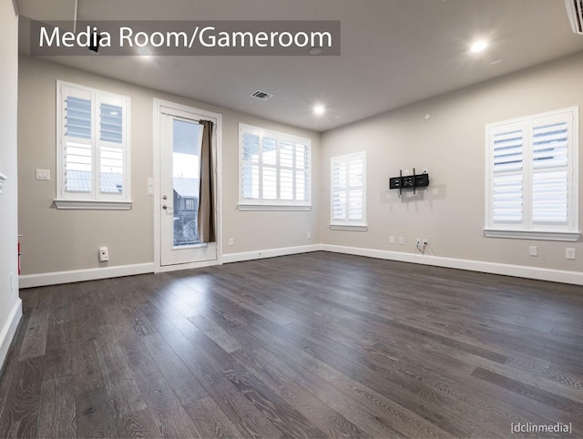 empty room featuring dark wood-type flooring, baseboards, and recessed lighting