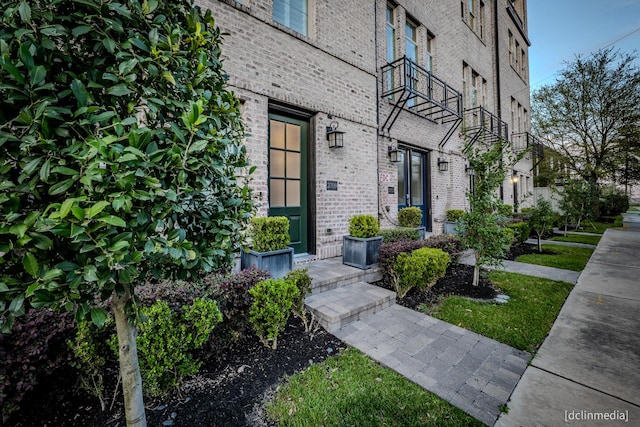 doorway to property featuring brick siding