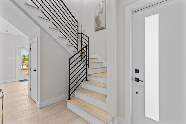 stairway featuring recessed lighting, wood finished floors, and baseboards