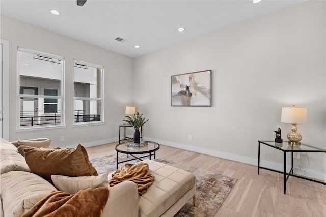 living area with recessed lighting, light wood-type flooring, and baseboards