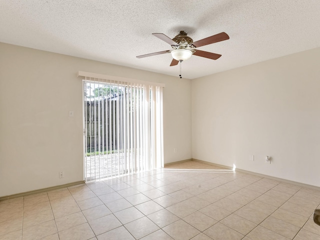 unfurnished room with baseboards, a textured ceiling, light tile patterned flooring, and a ceiling fan