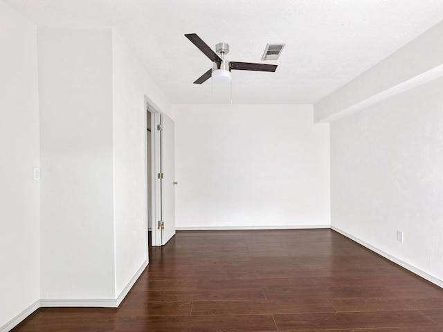 unfurnished room with visible vents, a textured ceiling, wood finished floors, baseboards, and ceiling fan