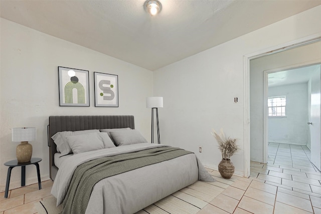 bedroom with light tile patterned floors and baseboards
