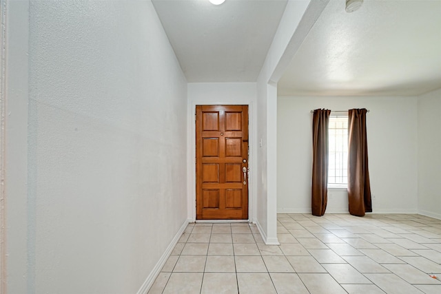 foyer entrance with baseboards and light tile patterned flooring