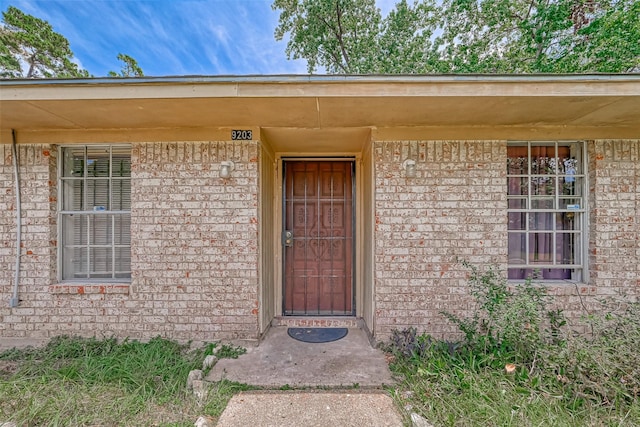 doorway to property with brick siding