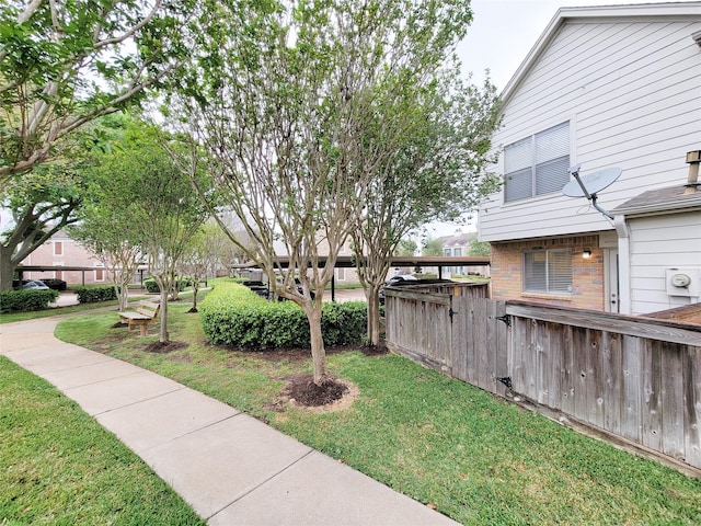 view of home's community featuring fence and a yard