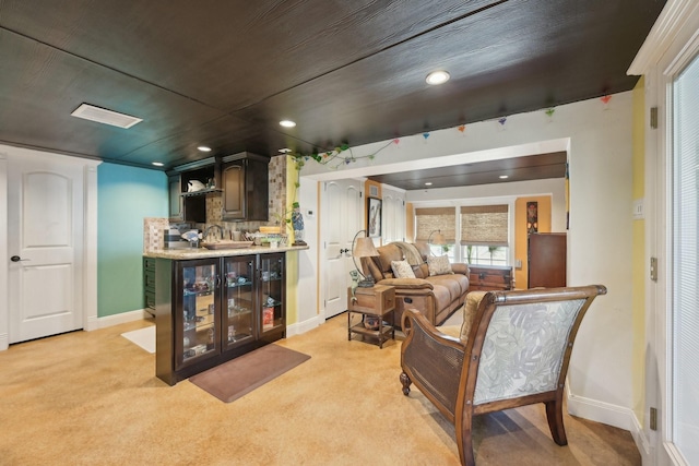 living area featuring bar, recessed lighting, baseboards, and light carpet