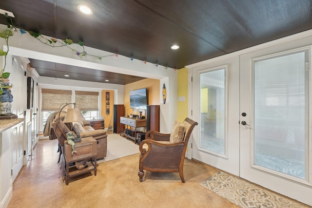 living area featuring light carpet, recessed lighting, and french doors