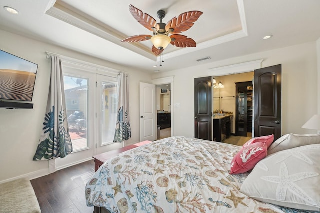 bedroom featuring a raised ceiling, access to exterior, visible vents, and dark wood-style flooring