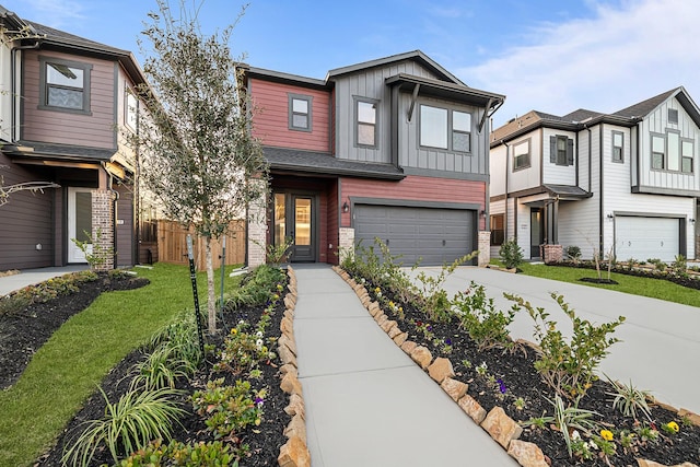 view of front facade featuring an attached garage, board and batten siding, driveway, and fence