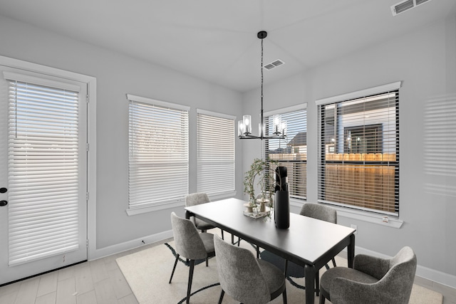 dining room with visible vents, baseboards, an inviting chandelier, and light wood finished floors