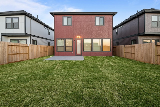 back of house with a patio, a lawn, and a fenced backyard