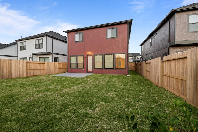 back of house with a lawn, a patio, and a fenced backyard