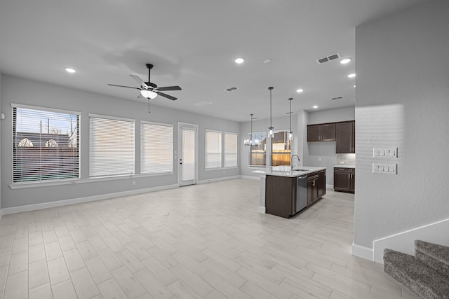 kitchen with a sink, visible vents, open floor plan, and ceiling fan with notable chandelier